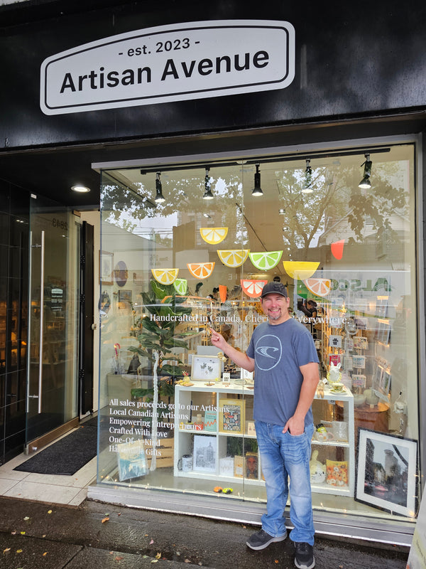 Person standing inside a store with 'Artisan Avenue' sign visible